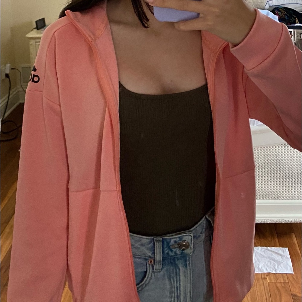 A pink adidas zip up hoodie.